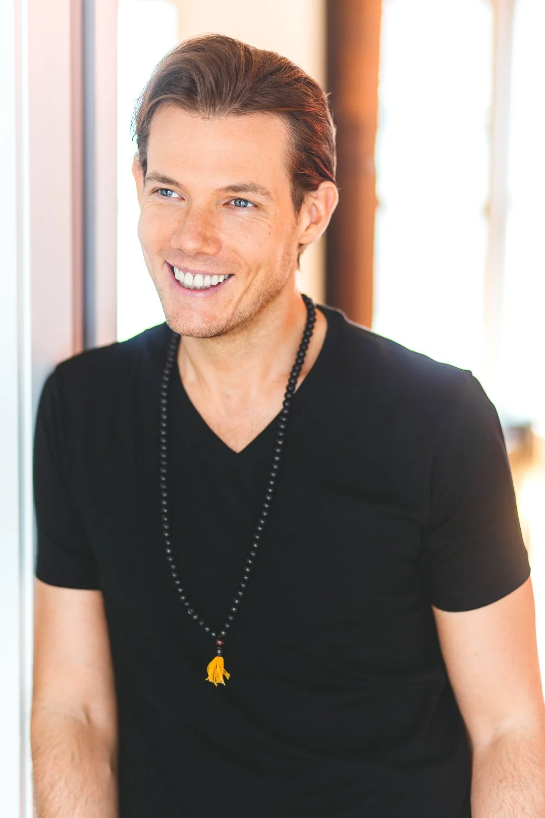 Sean Hayden standing indoors near a window with sunlight streaming in.
