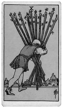 A man carries a large bundle of long sticks or poles on his back, leaning forward and using a support to hold them, with a rural landscape in the background.