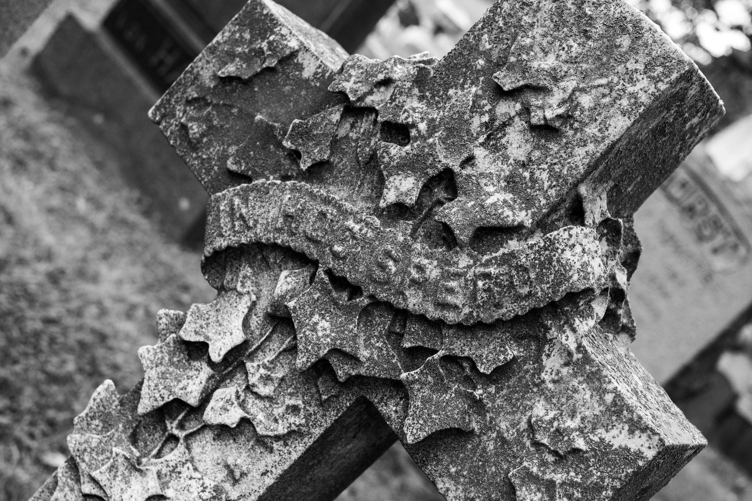 Close-up of a stack of weathered metal gears or cogs, showing rough texture and signs of rust or corrosion in black and white.