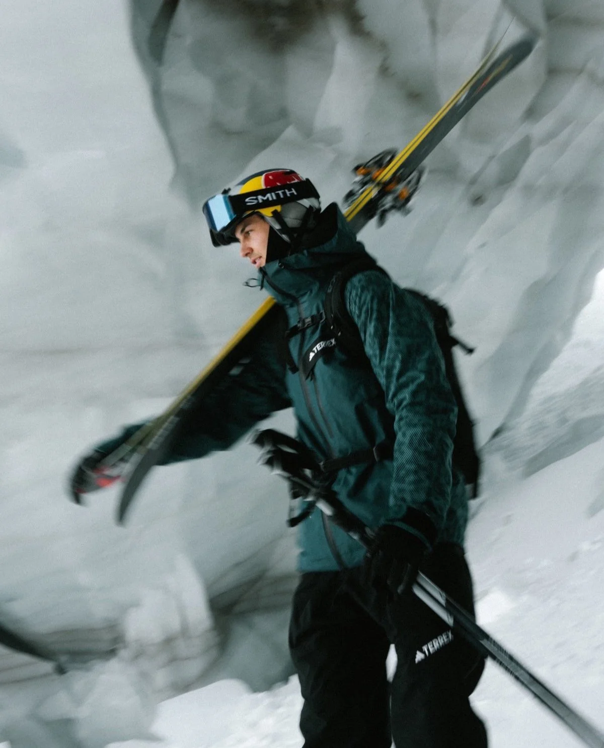 Mann in Winterkleidung trägt Skiausrüstung in einer eisigen Umgebung