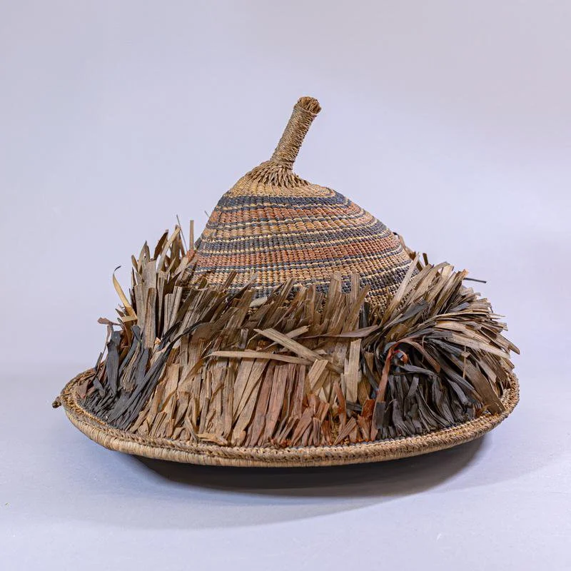 Hat that is conical in shape, with 'warp' ends gathered into a knob on top and wrapped with twisted leaves.