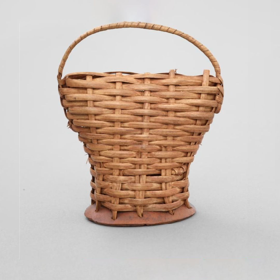 A dancing rattle, consisting of a wickerwork, bell-shaped base of hide. It contains seeds and has a looped handle at the top.