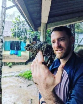 Manchester Museum Vivarium curatorial assitant Adam Trimmings holding a reptile.