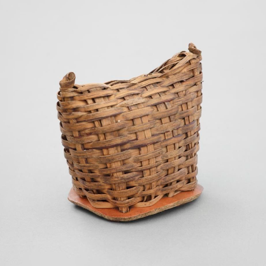An African rattle. The body is made out of basketwork, with a base made from a section of a large gourd. It is filled with seeds or small stones.