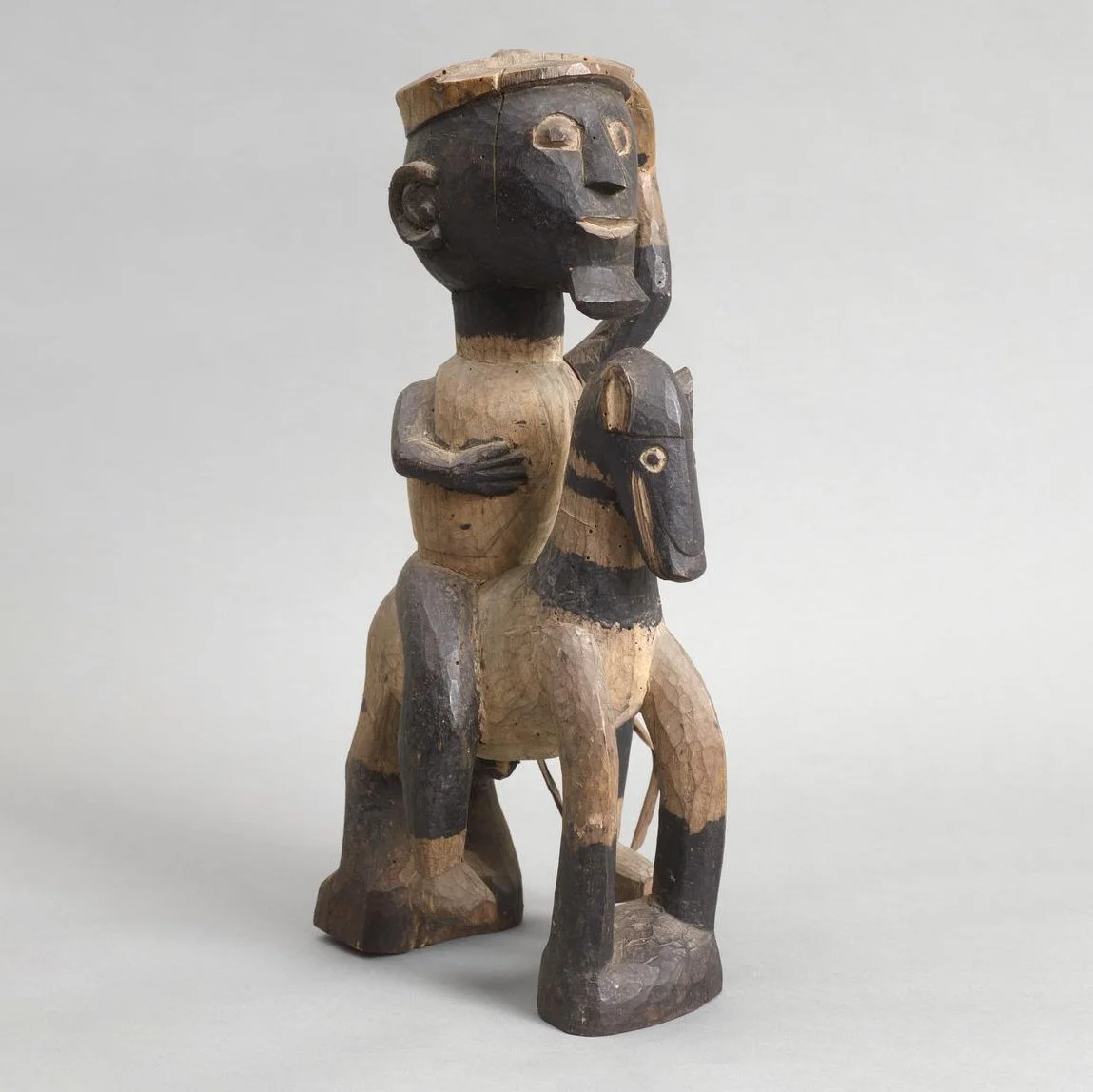 A carved wooden figure of a man on a horse.