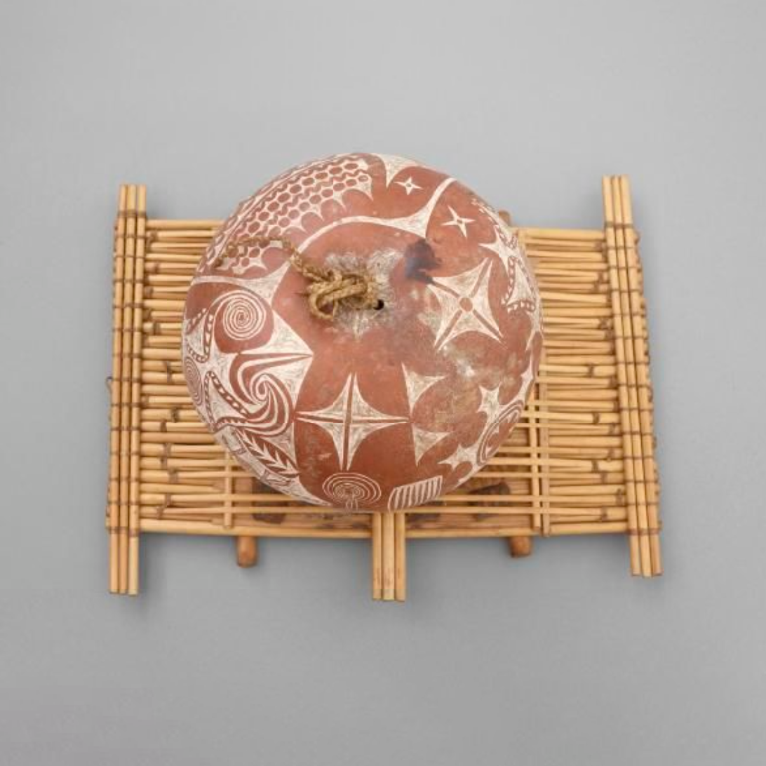 A musical instrument. The body of the instrument is made of canes lashed side by side. Strips of these canes are raised on wooden 'bridges' and wrapped with cane to form the 'strings'.