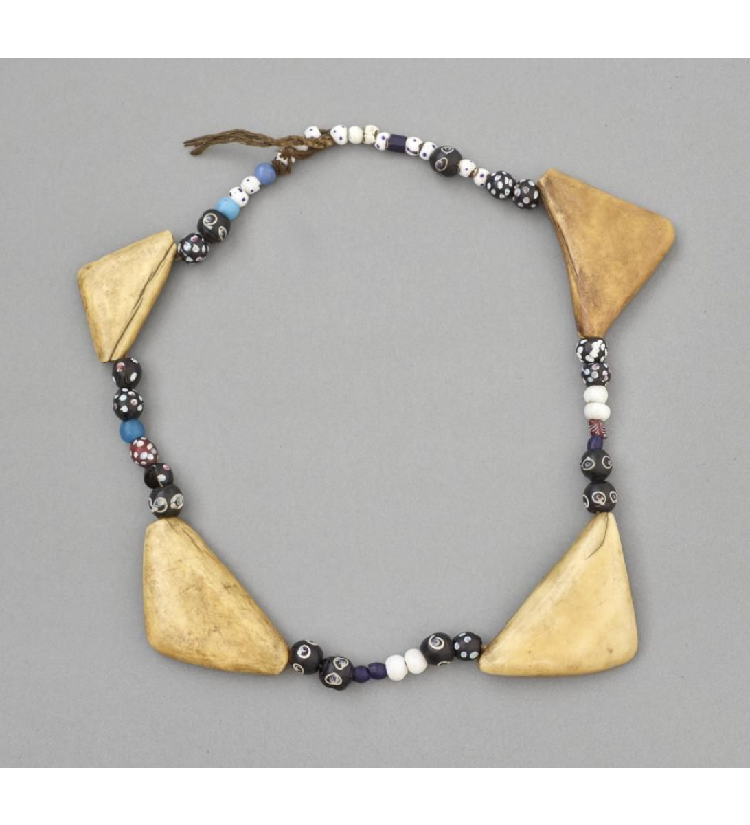 A necklace consisting of large glass beads, many of them spotted, and four large triangles of bone. All threaded onto string.