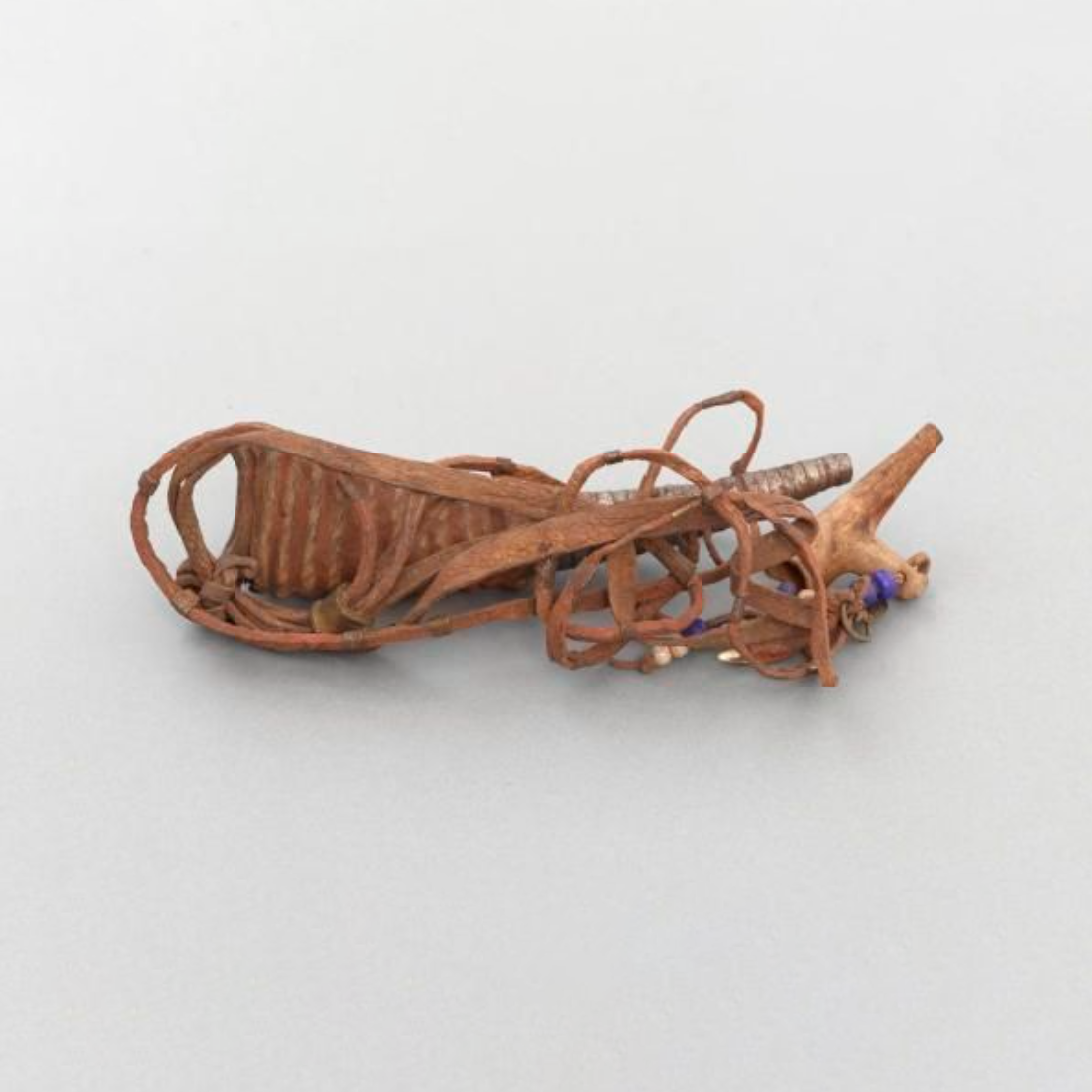 A nose flute and whistle. The nose flute is made from the tip of a horn covered with leather and an iron strip. There are leather thongs attached.