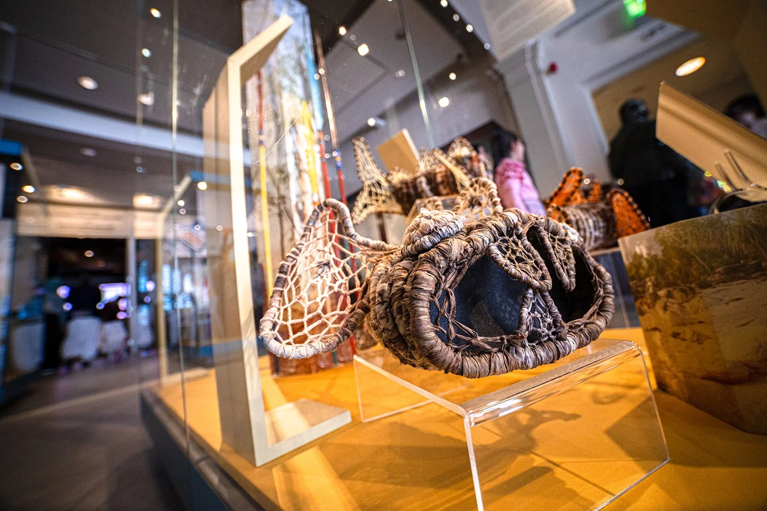 Display of colourful Yilkwa (monster fish) created from reclaimed fishing nets by the Anindilyakwa community and mounted in display cases, as part of the exhibition Aninidlyakwa Arts: Stories from our Country at Manchester Museum.