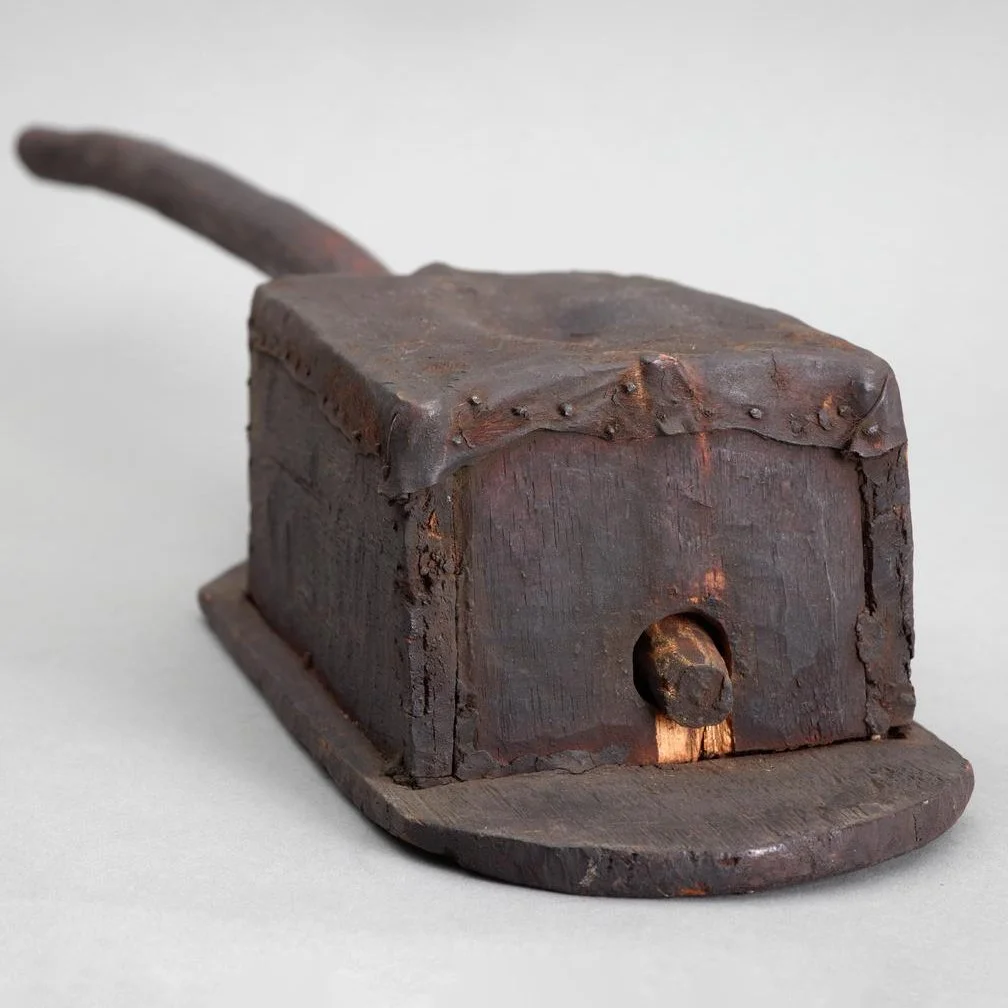 Musical instrument with a sound box constructed of flat pieces of wood nailed together with a leather membrane. The 'neck' is a slightly curved stick of hard wood.