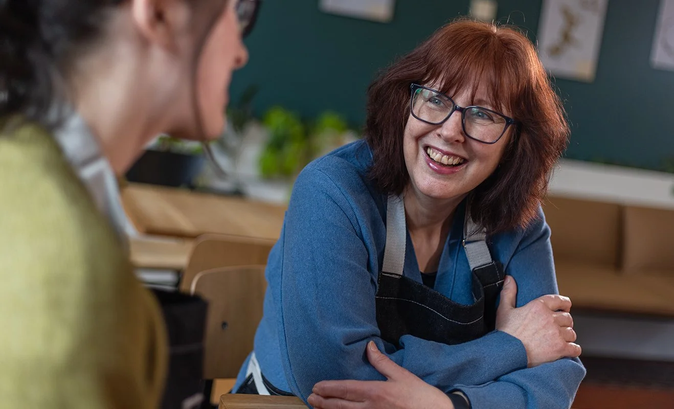 Manchester Museum volunteer Lys Cleary, smiling while in conversation.