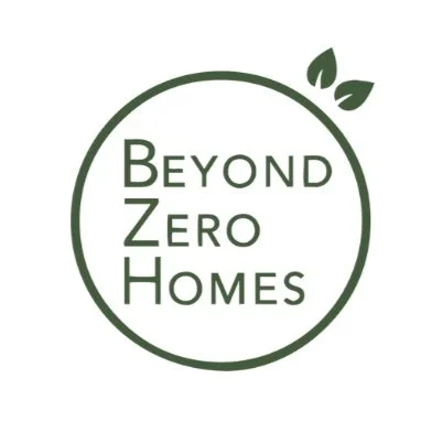 Logo for Beyond Zero Homes featuring a green circle with two leaves at the top and the company name inside.
