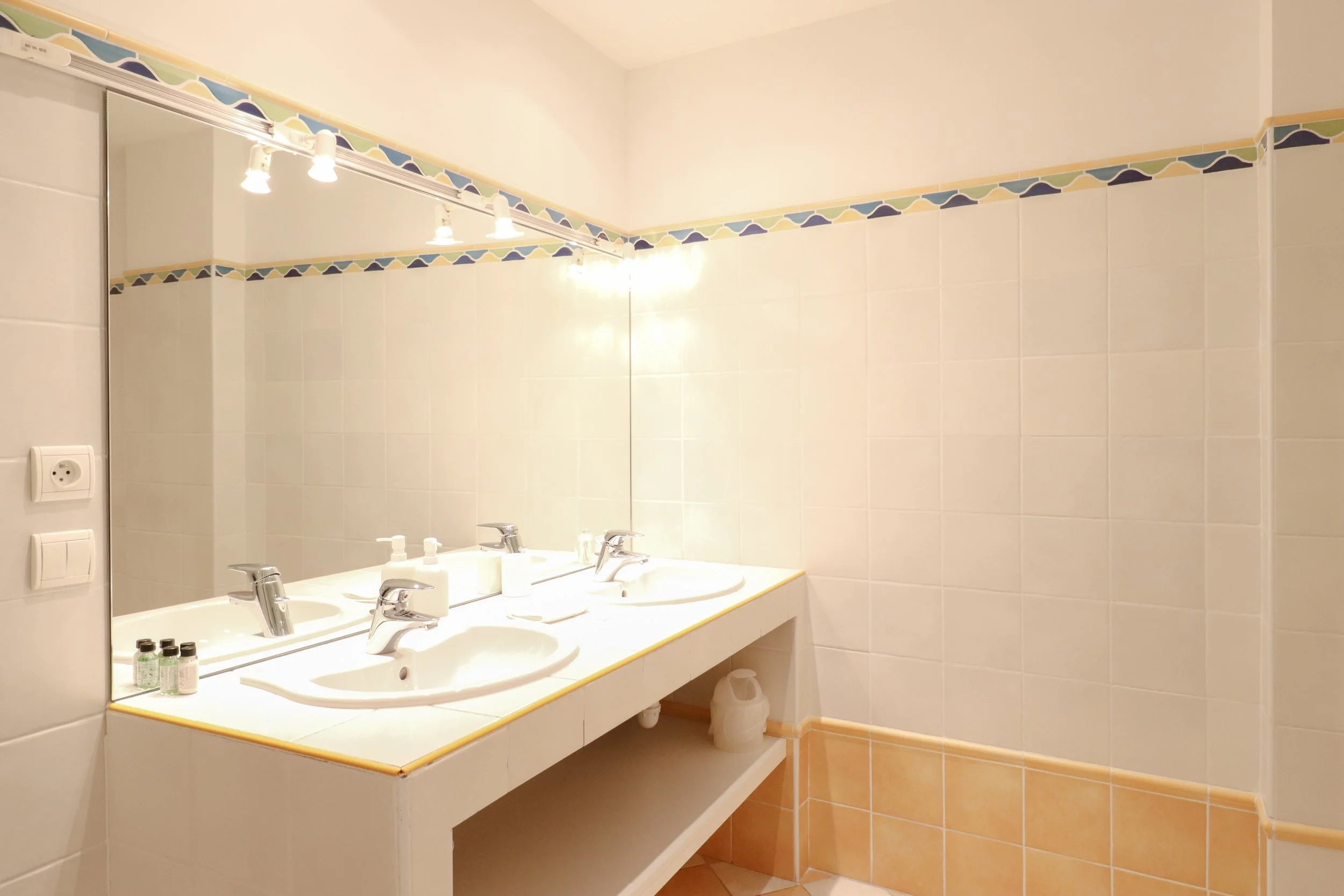 Salle de bain avec deux lavabos, miroir et éclairage