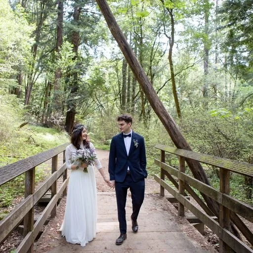 Couple walking hand in hand across a wooden bridge at Fall Creek in Henry Cowell Redwood State Park — intimate redwood elopement in Santa Cruz, California