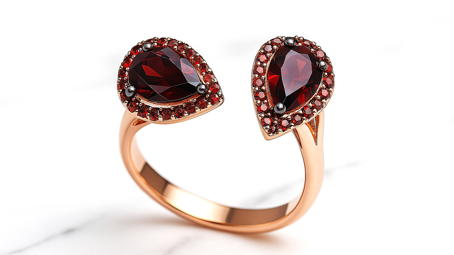 Rose gold ring with two heart-shaped garnet gemstones surrounded by small red gemstones.