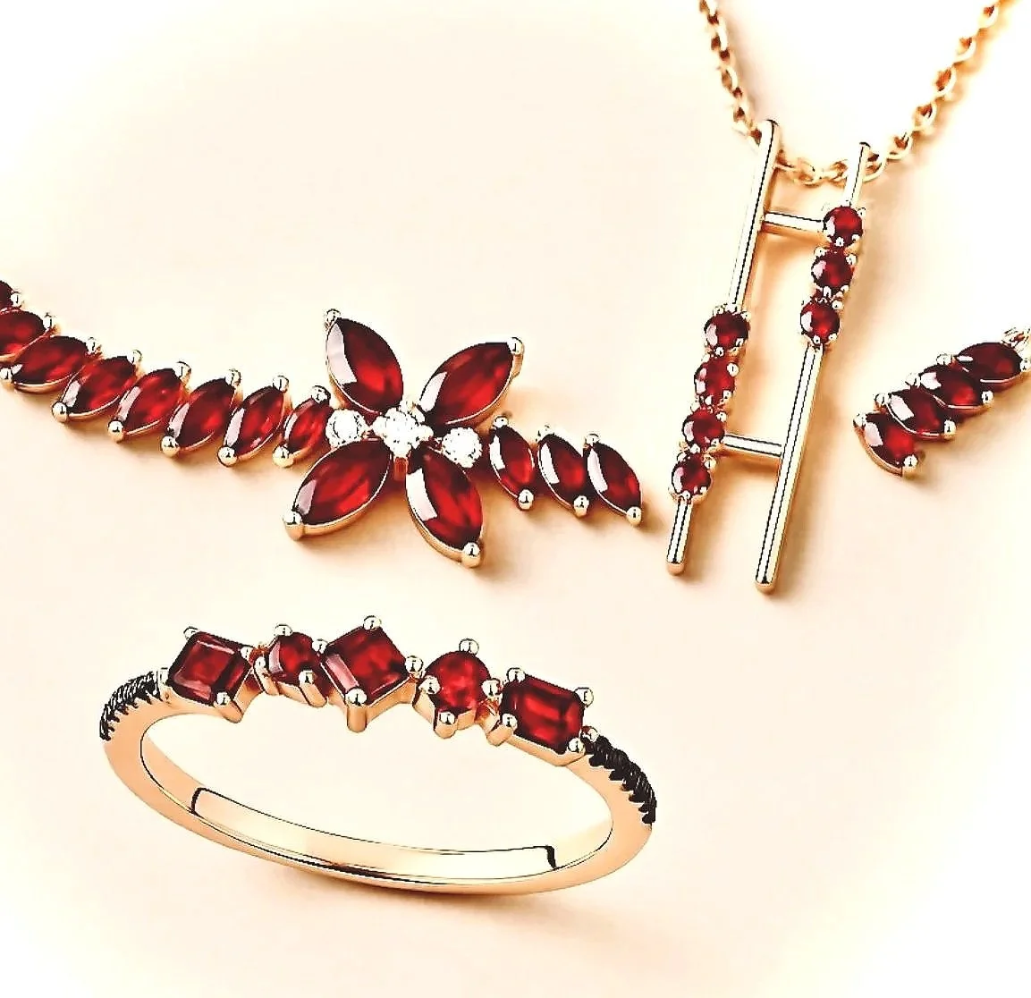 Jewelry set including a necklace with red gemstones and a floral design, a matching ring with red stones, and a gold bracelet with red gemstones.