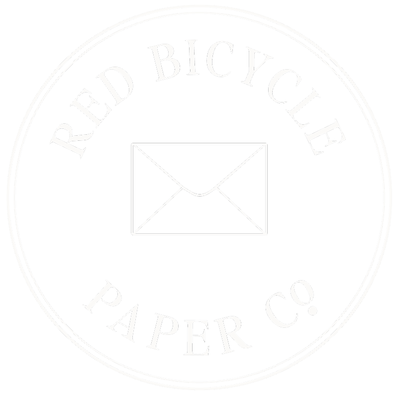 Logo for Red Bicycle Paper Co. featuring an envelope icon inside a black circular background with white text.