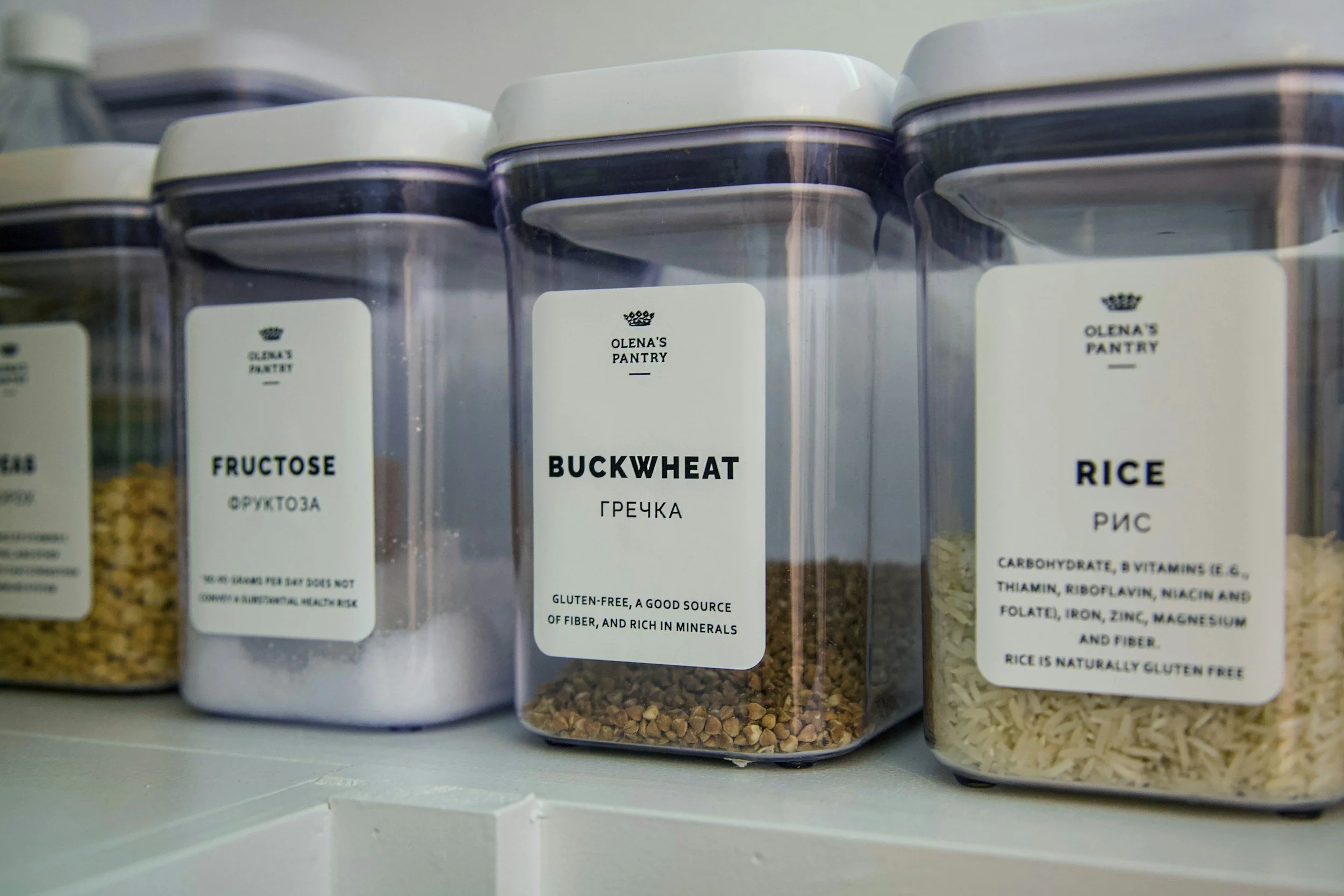 Organized kitchen pantry with clear, labeled food storage containers for grains and dry goods, designed for easy access and visibility.