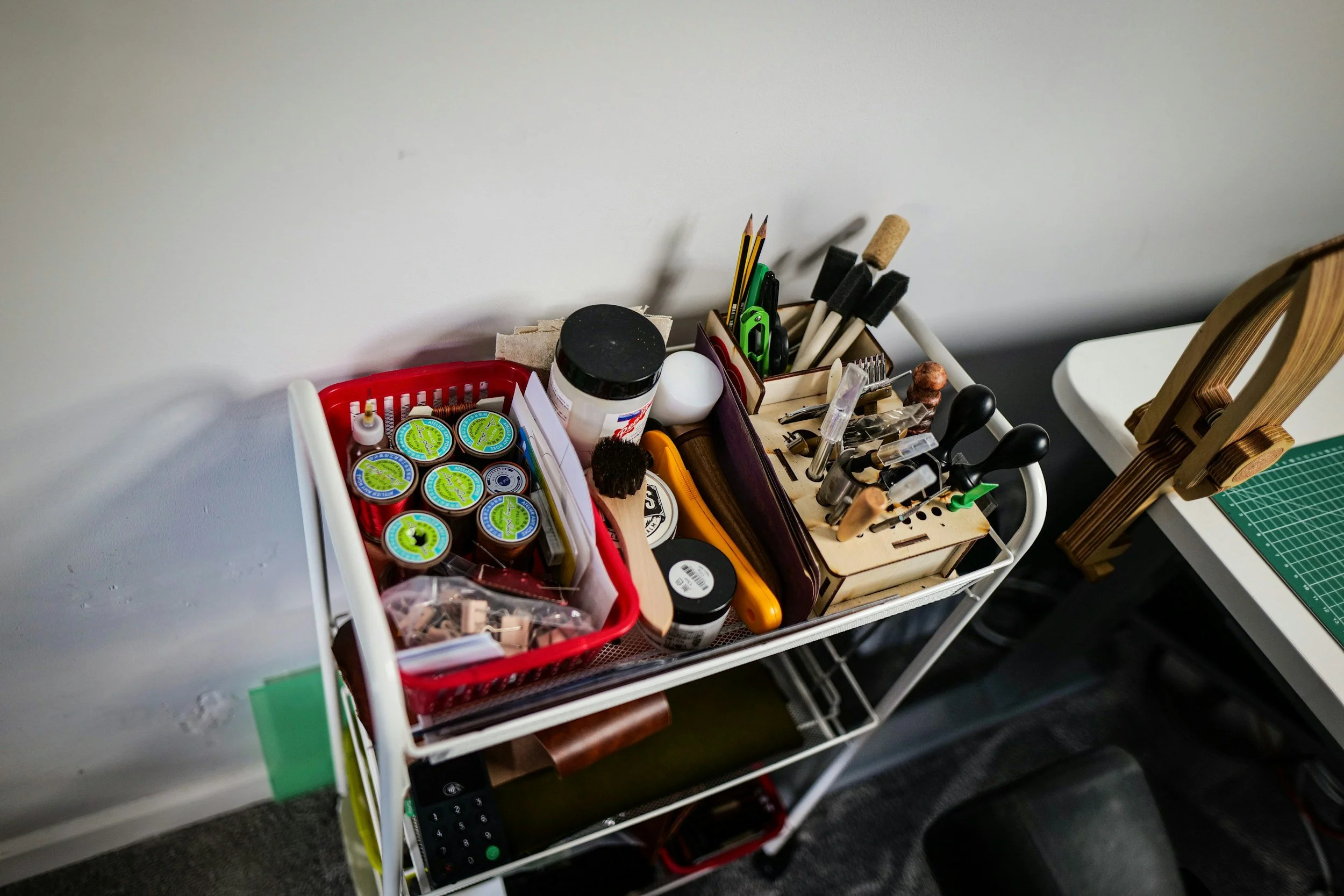 Organized craft storage cart with labeled containers and tools in a St. Louis craft room workspace