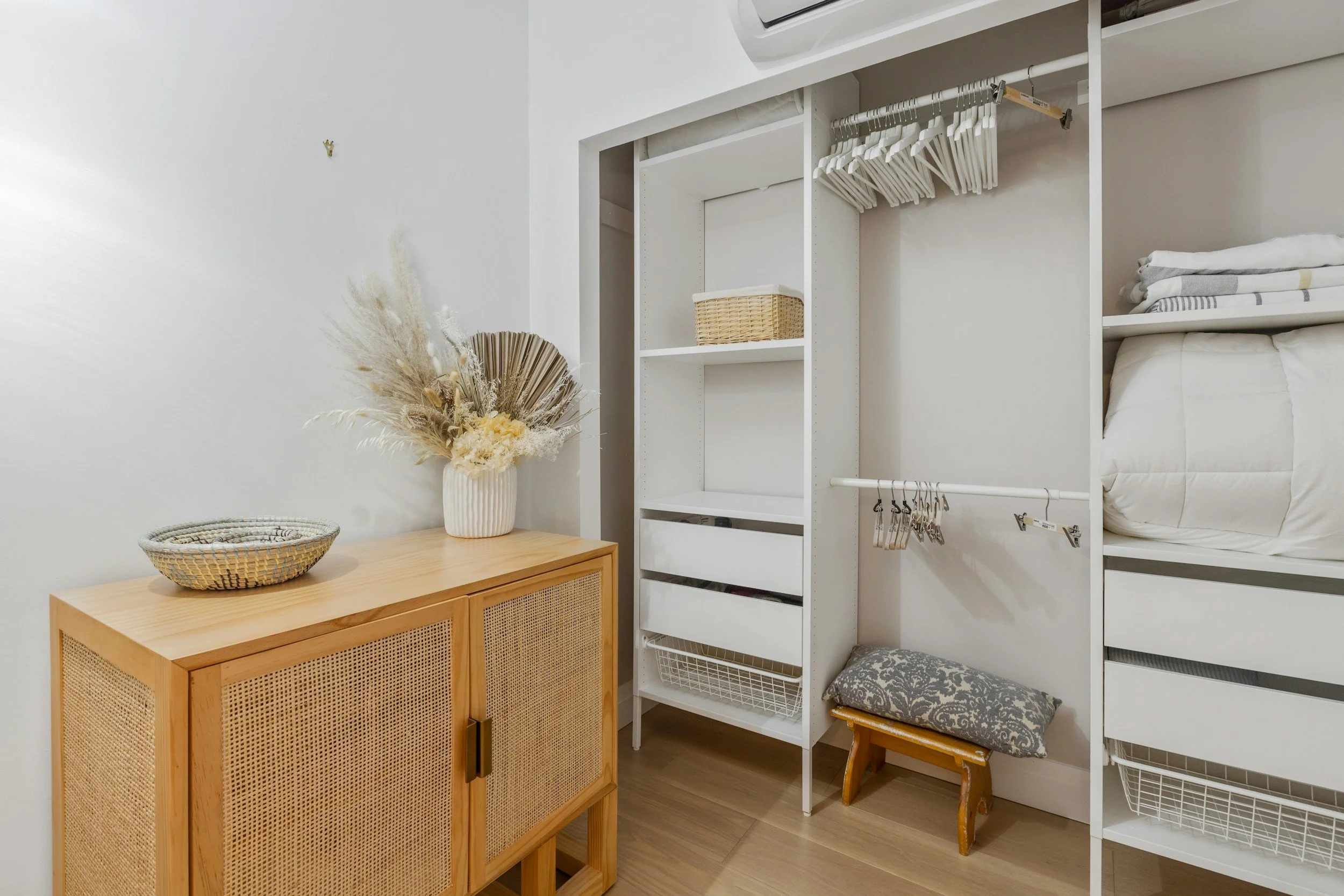 Master closet organization with shelving, baskets, and hanging rods for clothing and linens in a St. Louis home