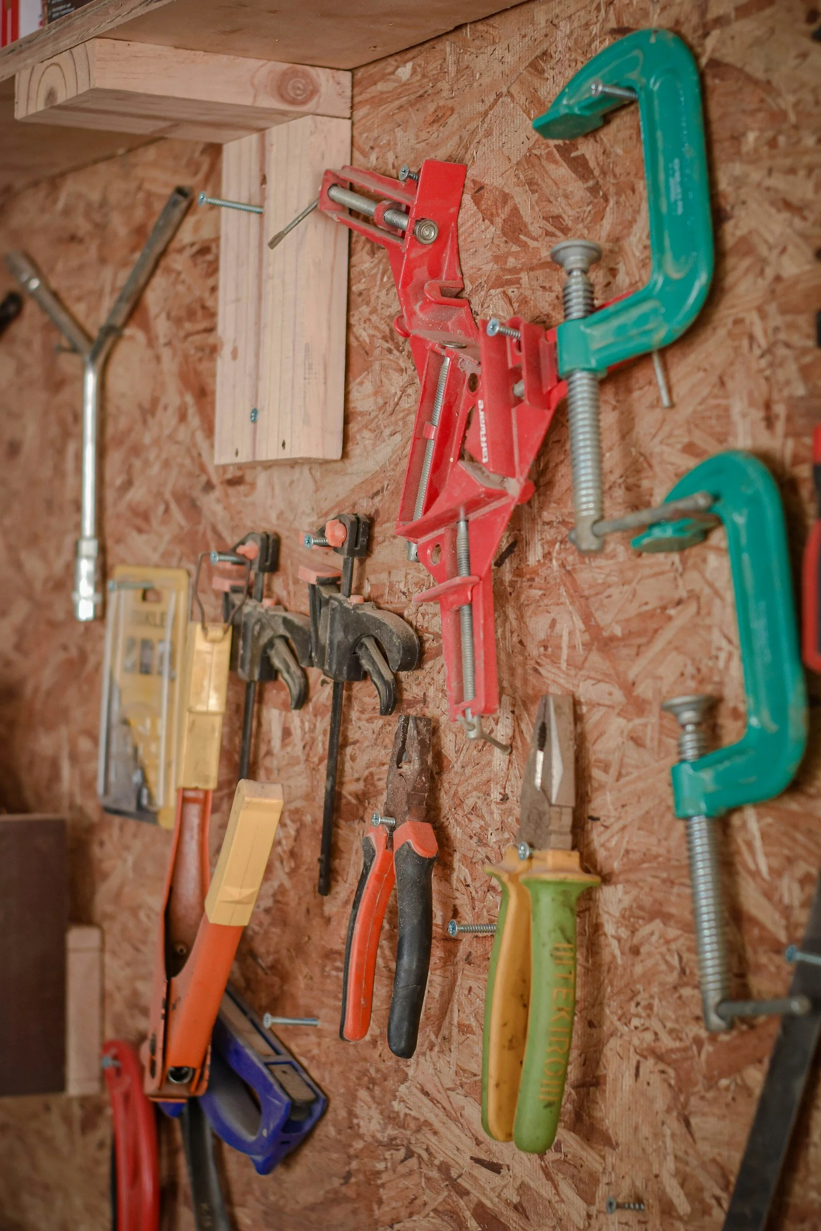 Neatly organized garage wall with hanging hand tools and workshop storage in a St. Louis home