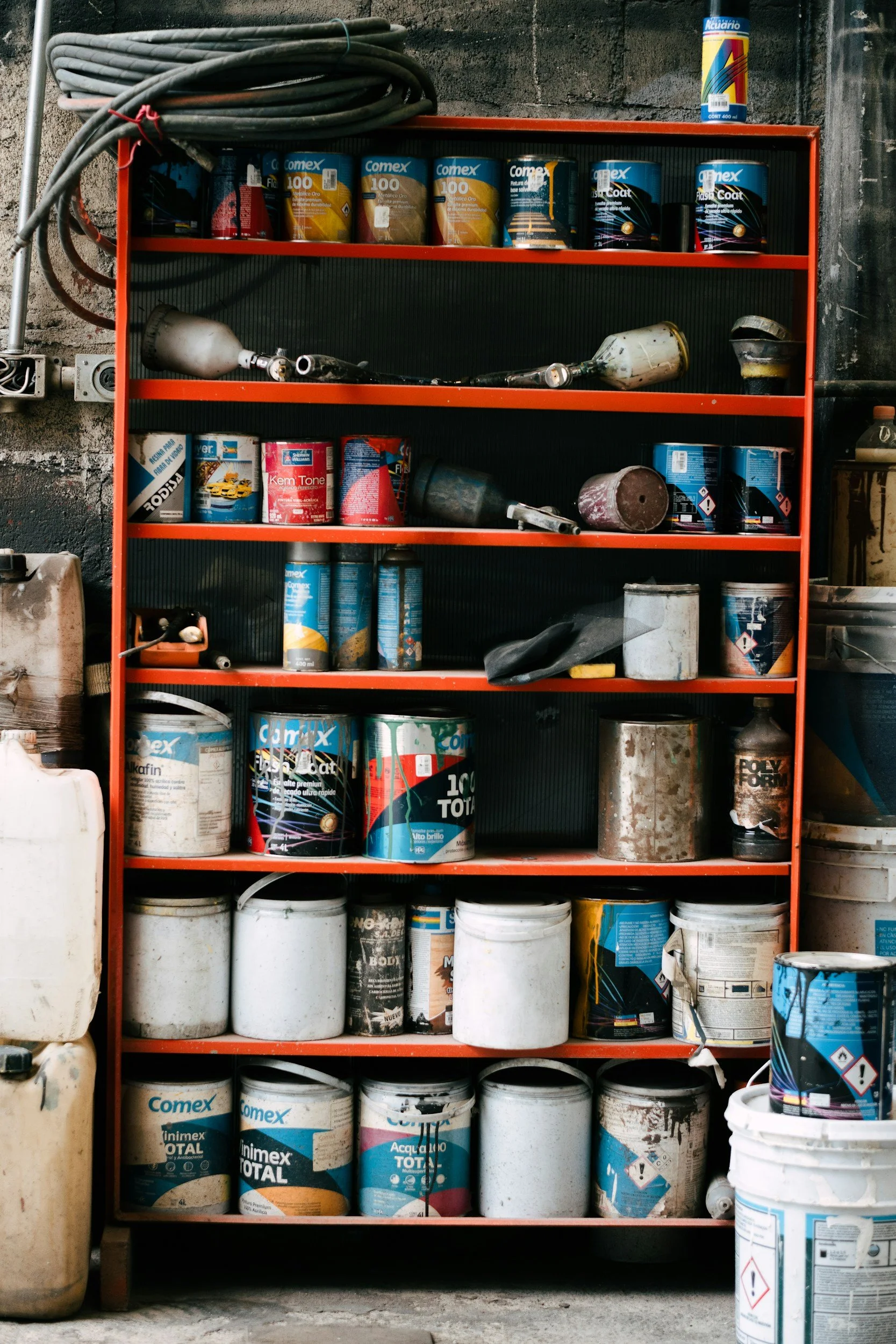 Organized garage shelving with paint cans and household supplies neatly stored in a St. Louis home