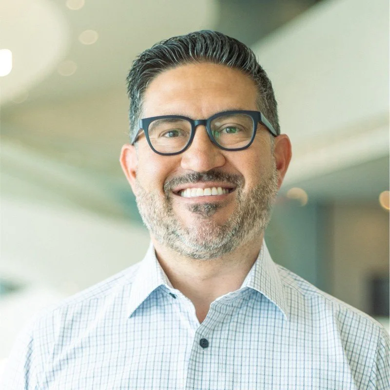 Smiling man wearing glasses and a checkered shirt