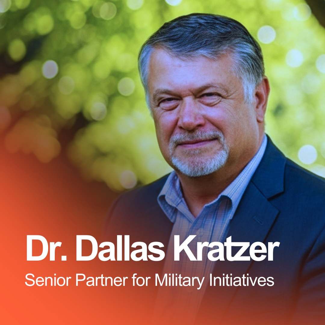 A professional portrait of Dr. Dallas Kratzer, a senior partner for military initiatives, outdoors with a blurred green background.