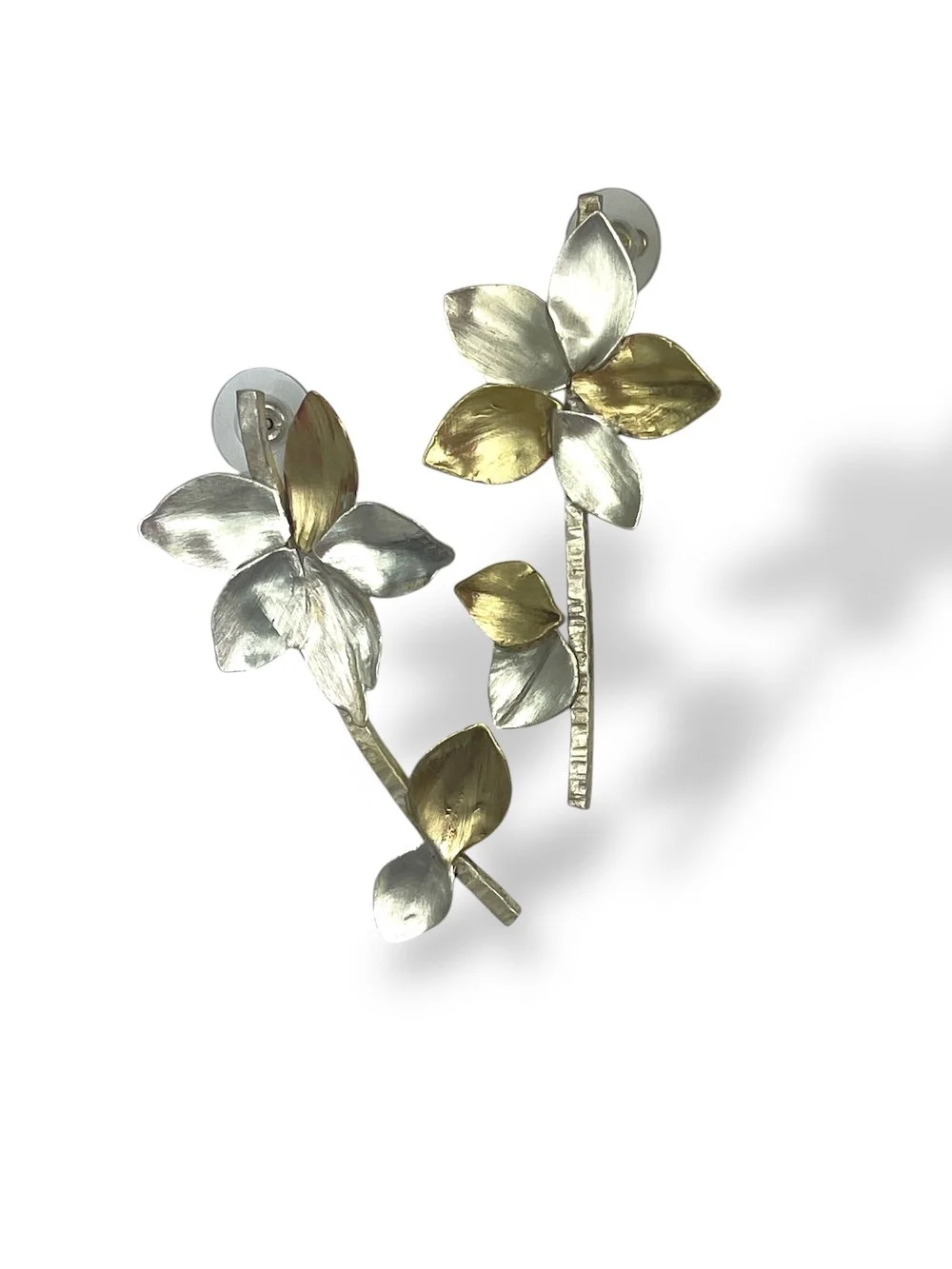 Gold and silver flower-shaped earrings with leaf and stem designs.