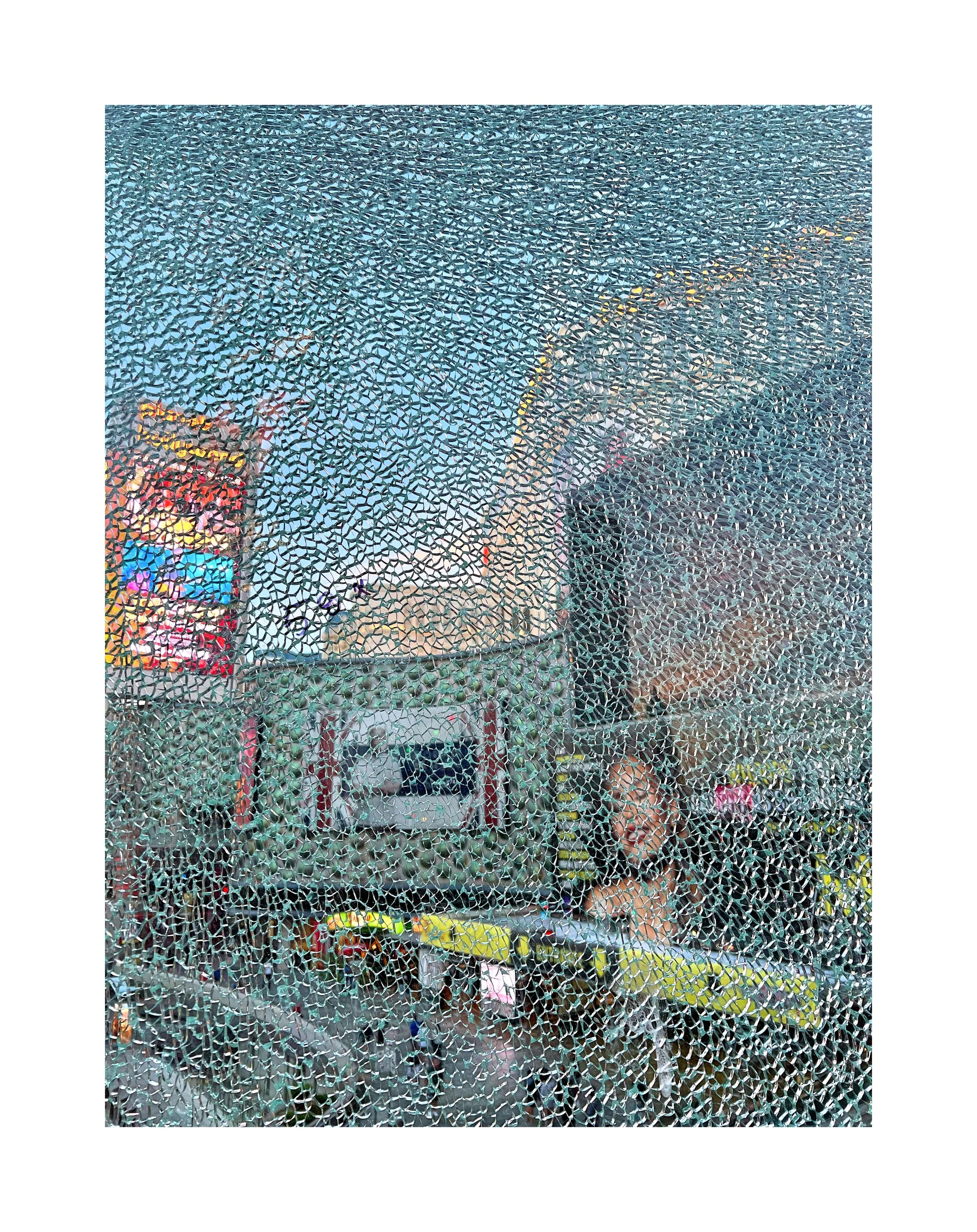 Une affiche publicitaire visible derrière une vitre brisée.