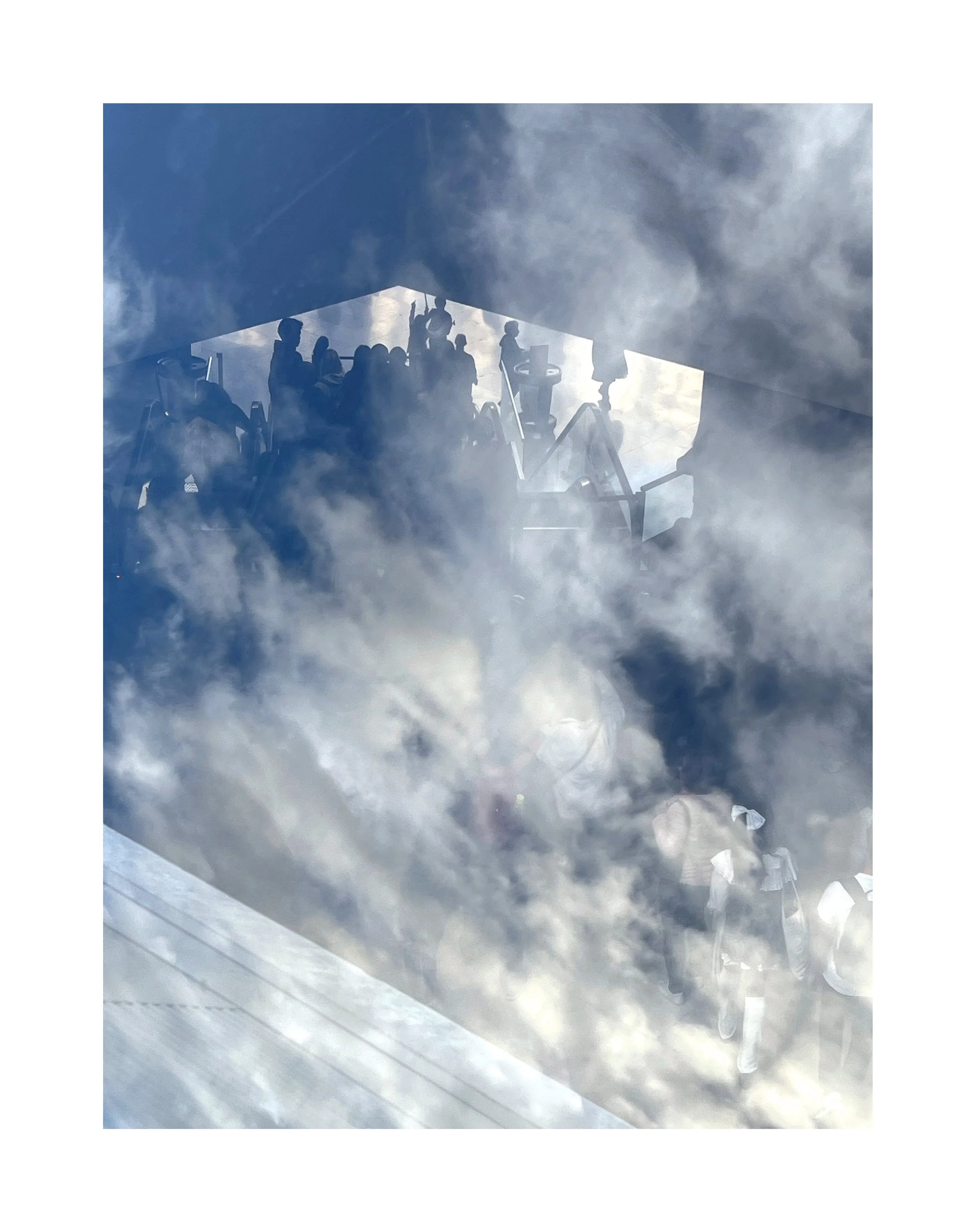 Reflexion d'un groupe de personnes à travers une surface vitrée avec ciel et nuages visibles.