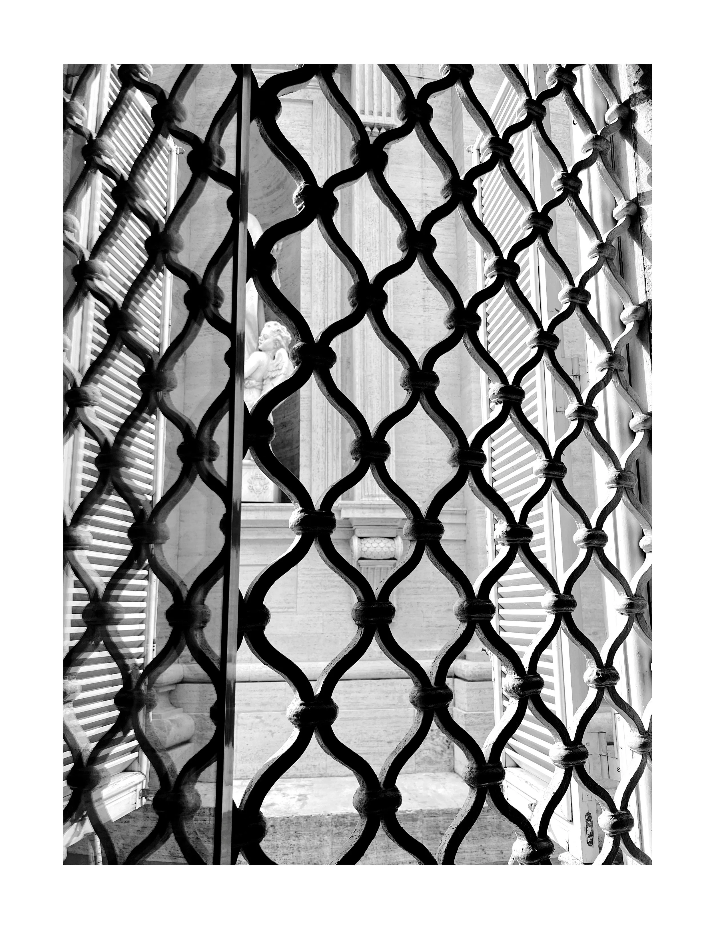 Vue intérieure d'une grille en fer forgé noir devant une fenêtre avec volets et une statue de lion en pierre à l'intérieur d'une architecture en pierre.