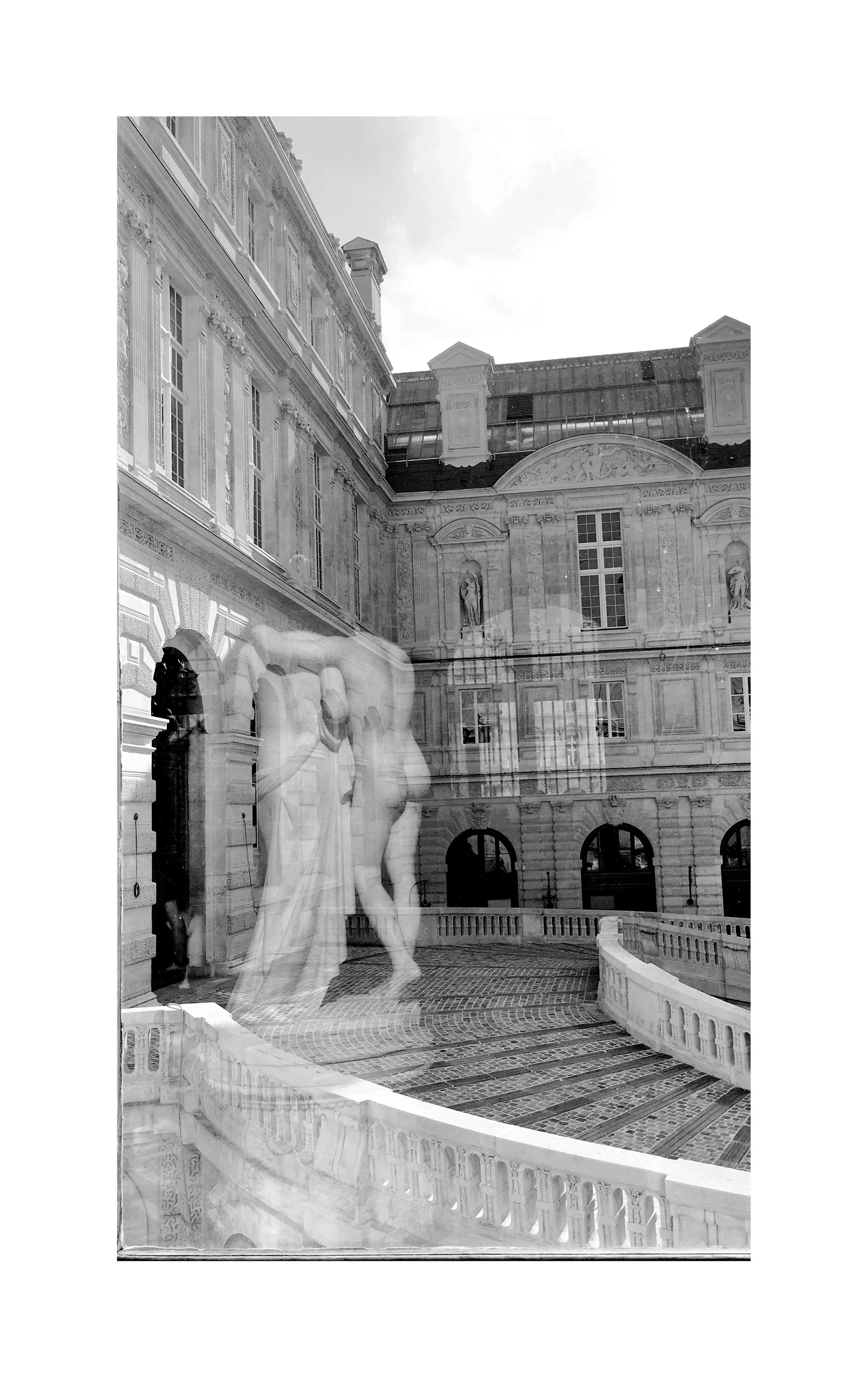 Vue d'une cour intérieure d'un bâtiment historique avec des sculptures, des fenêtres hautes et une façade ornée, vue à travers une fenêtre avec des reflets de silhouettes humaines.