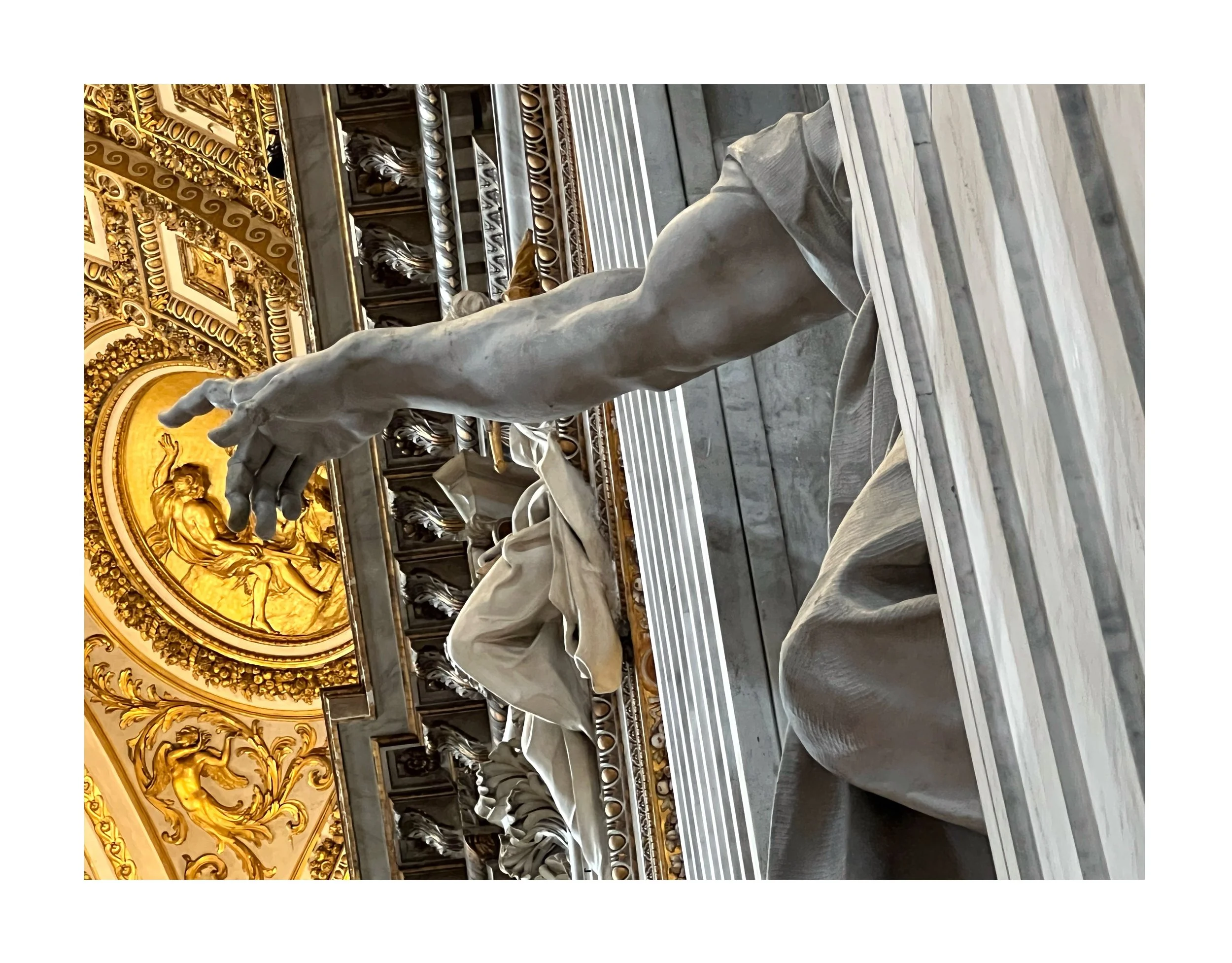 Statue de marbre représentant une main tendue, dans un intérieur orné de dorures et de sculptures détaillées.