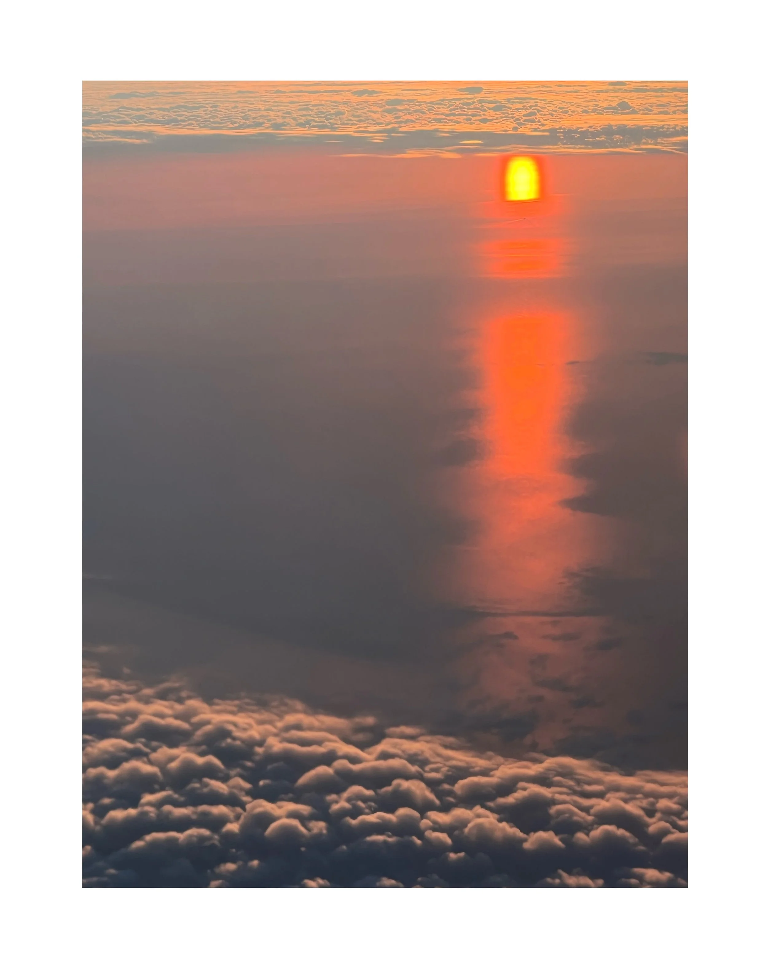 Coucher de soleil spectaculaire avec des nuages colorés et leur reflet dans l'eau.
