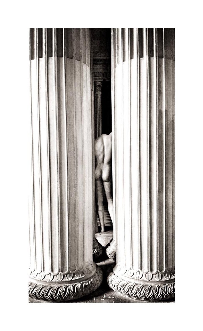 Une sculpture classique de dos, située entre deux colonnes monumentales en marbre