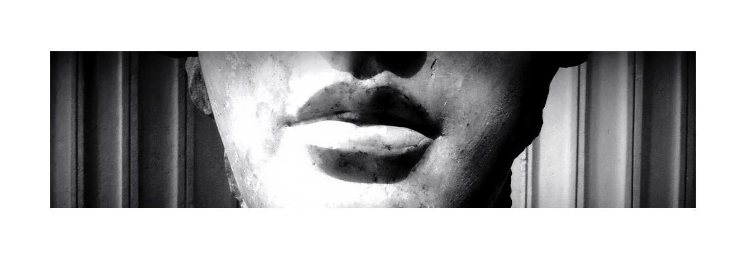 Statue en marbre d'un visage humain, zoom sur les lèvres, en noir et blanc.