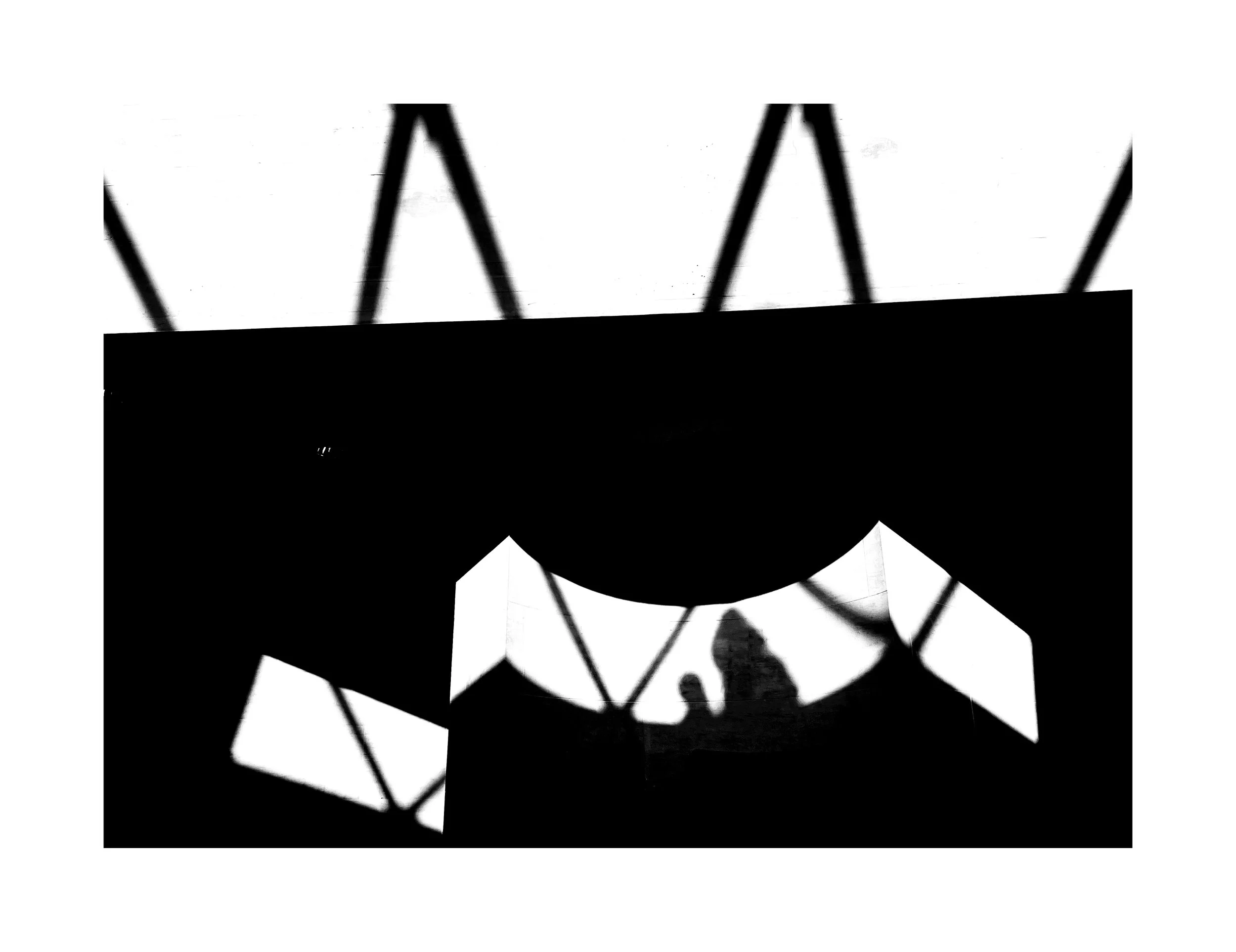 Silhouette d'une personne en haut d'une montgolfière avec un logo en forme de moustache sur le ballon, vu à travers une structure en treillis.