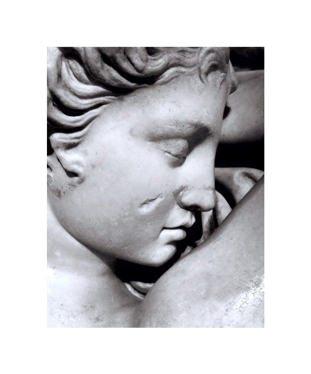 sculpture en marbre d'une femme avec des cheveux ondulés, vue en profil.