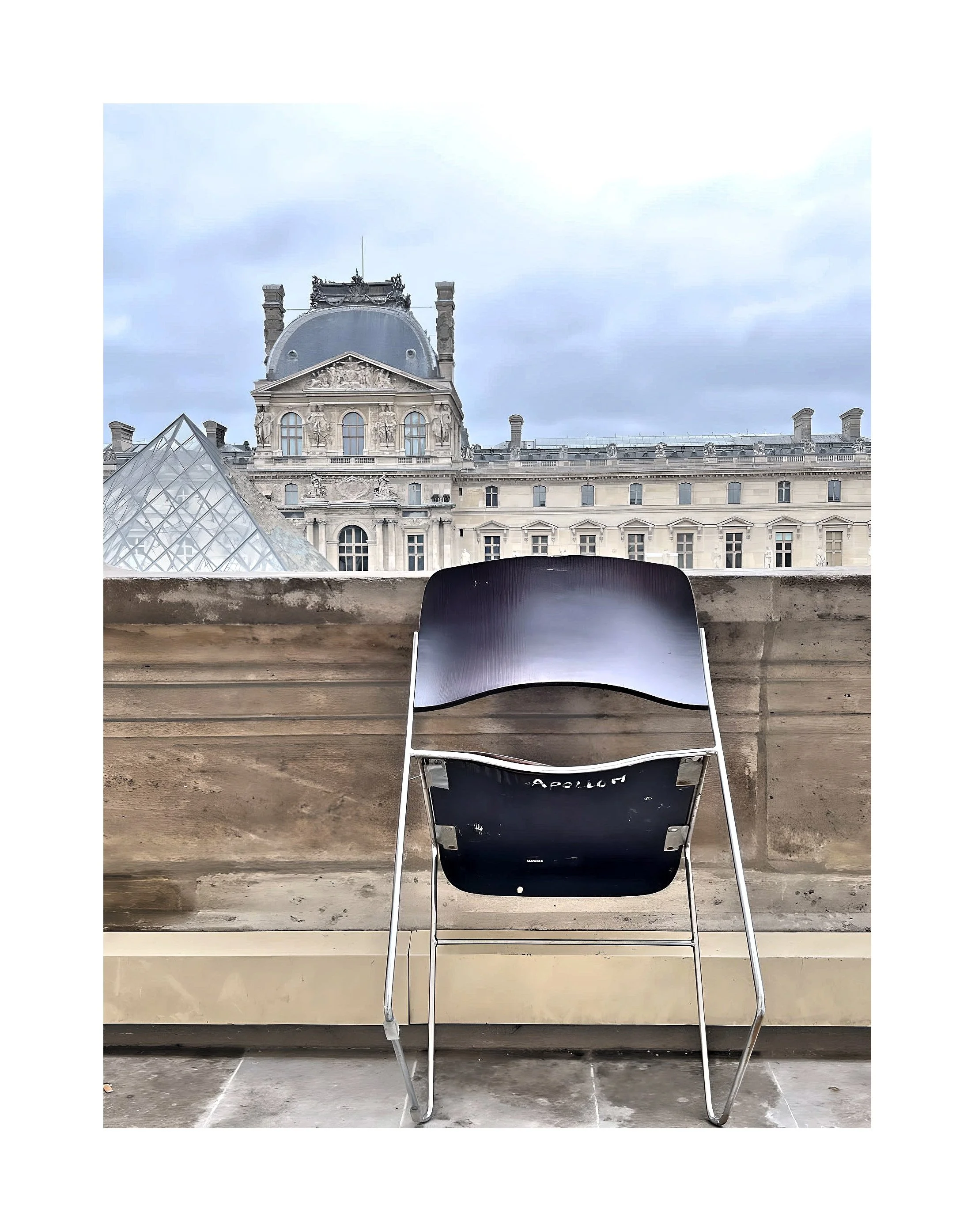 Chaise en plastique noir sur un balcon avec vue sur un bâtiment historique parisien