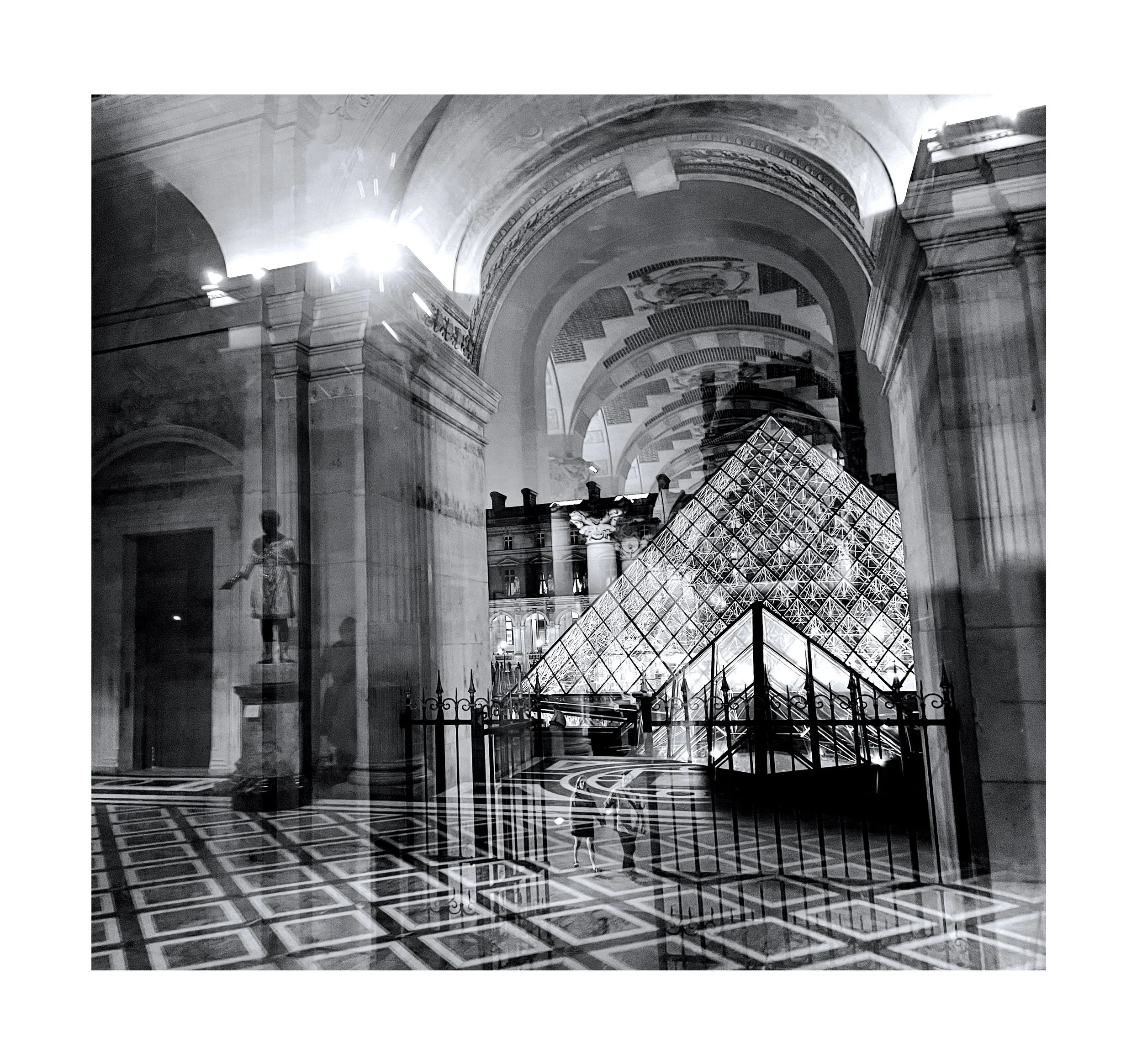 Photo en noir et blanc de l'intérieur du Louvre à Paris, avec la pyramide en verre illuminée au centre et des arches architecturales entourant la scène.