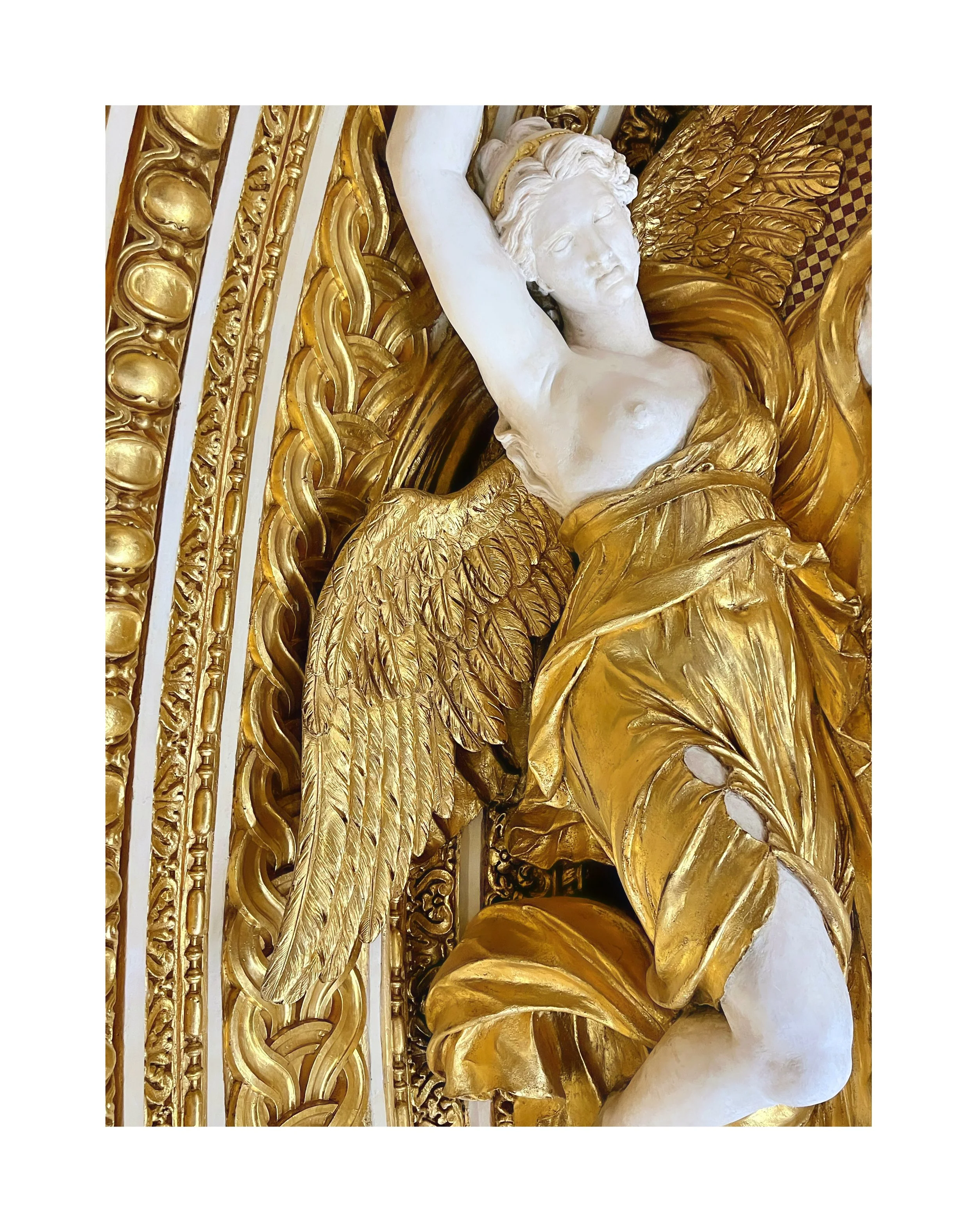 Sculpture représentant un ange avec des ailes dorées, en relief avec des détails sophistiqués, en partie en marbre blanc et en or, dans un style baroque.
