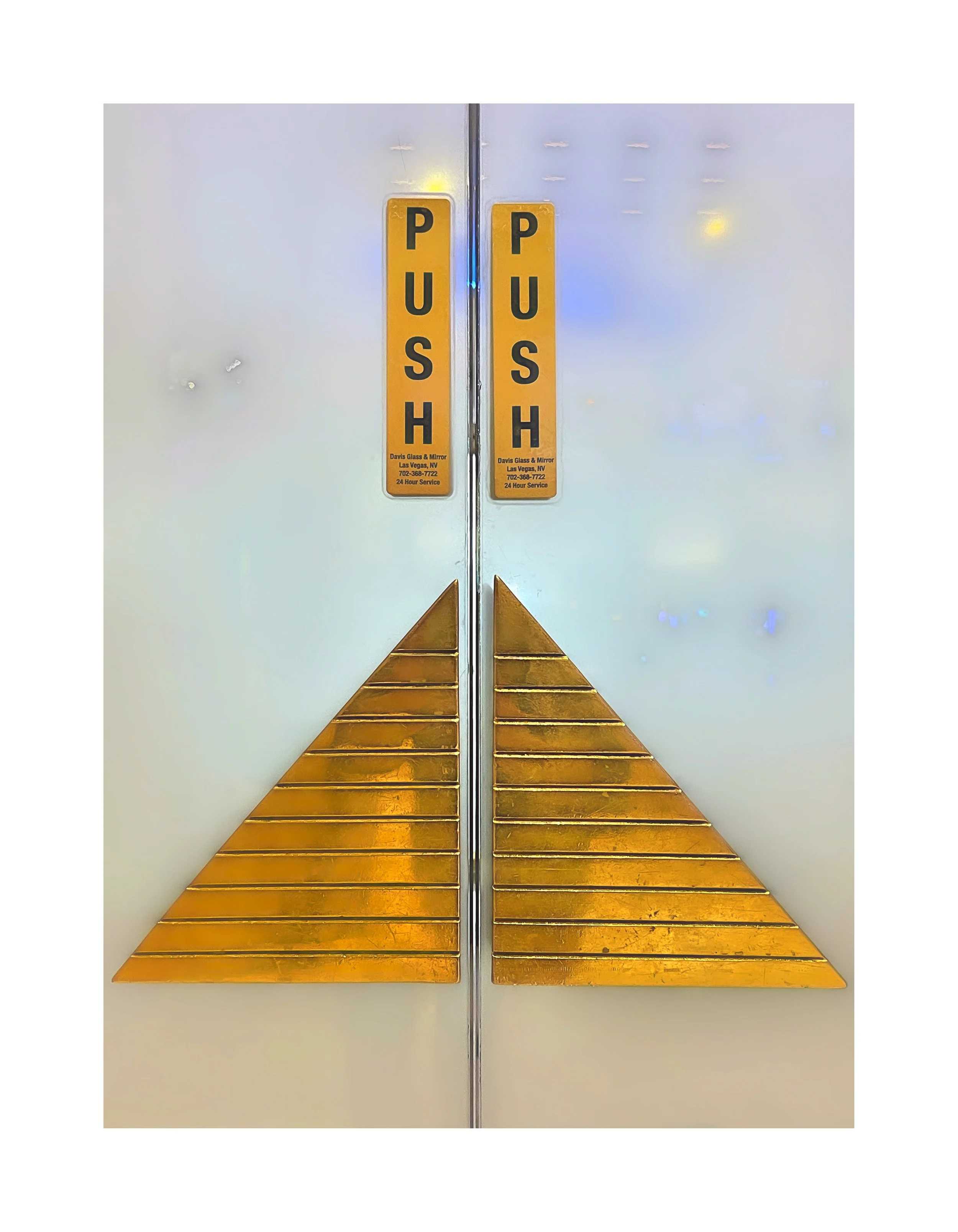 Panneau indiquant 'PUSH' sur une porte avec des bandes dorées en dessous.