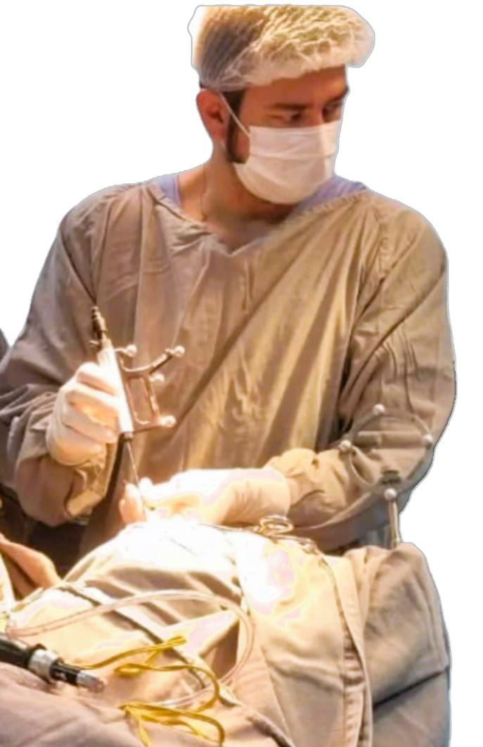 Profissional de saúde realizando procedimento médico usando máscara, touca, luvas e equipamento cirúrgico.