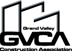 A simple black icon of a desk with a computer monitor, keyboard, and a chair in a minimalist style.