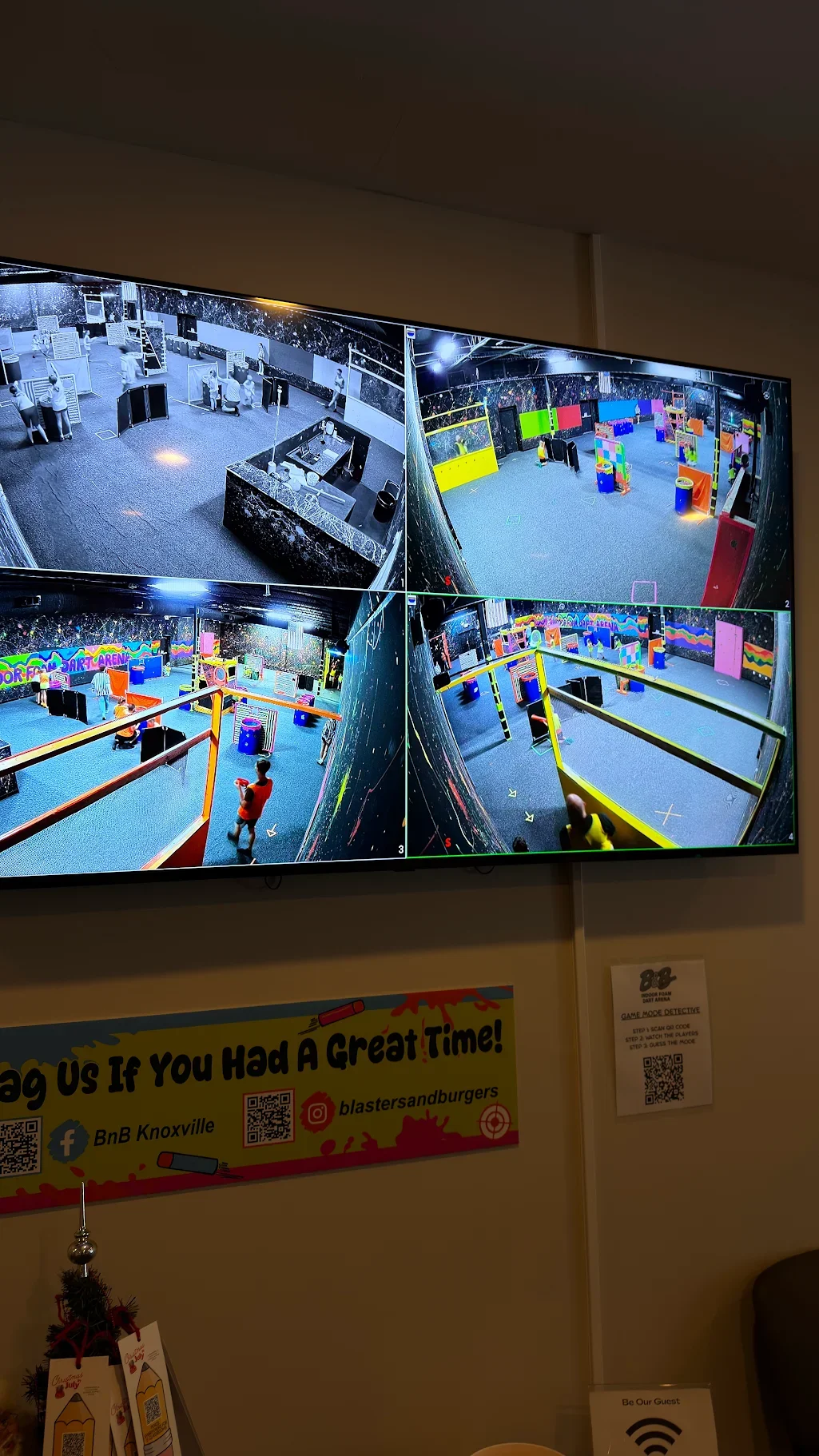 Screens showing multiple views of an indoor NERF arena with colorful barriers