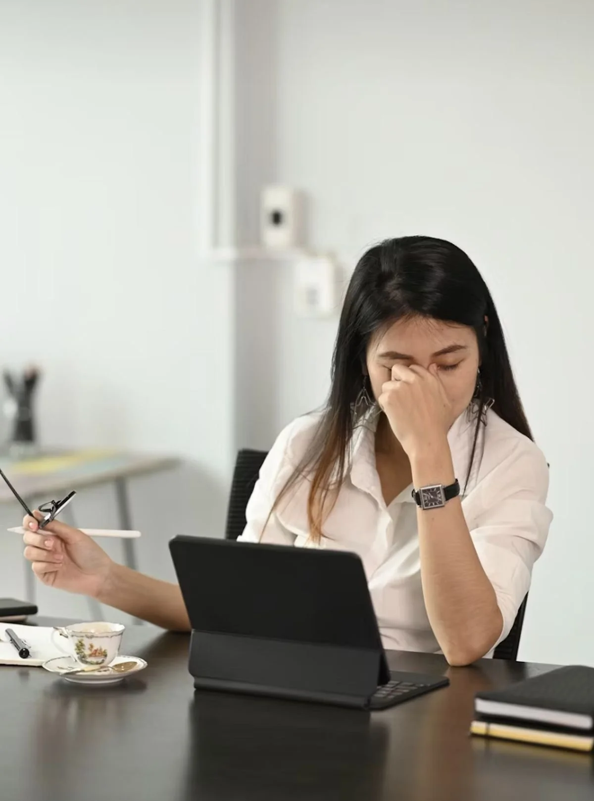 Woman sitting at a desk with head resting on folded arms, symbolizing exhaustion and burnout recovery in Salt Lake City.