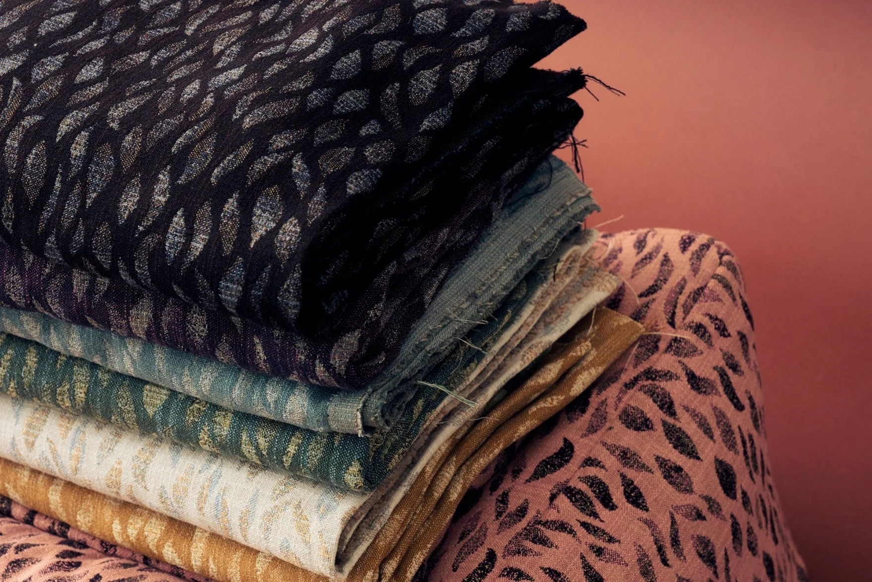 A stack of Petals Woven colorways by Rebecca Atwood, from Brown/Black to Ochre