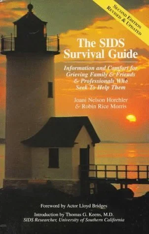 Cover of the book titled 'The SIDS Survival Guide,' featuring a lighthouse at sunset with a yellow banner indicating 'Second Edition Revised & Updated.' The subtitle reads 'Information and Comfort for Grieving Family & Friends & Professionals Who See