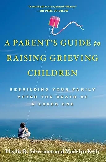 Book cover titled "A Parent's Guide to Raising Grieving Children" by Phyllis R. Silverman and Madelyn Kelly. The cover features a child sitting on grass near water, flying a pink kite in a blue sky.